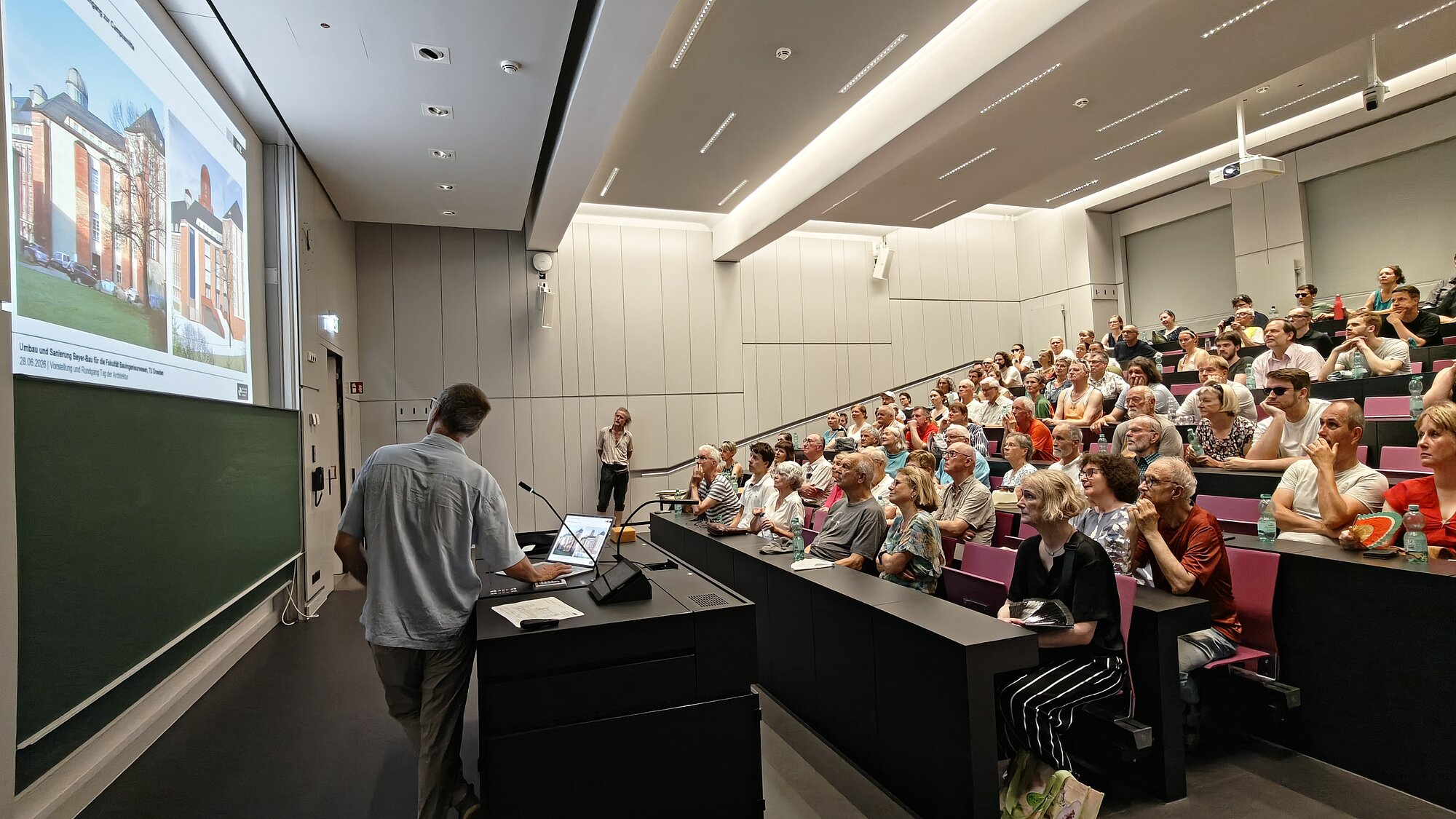 Die Besucher der Veranstaltung lauschen dem Vortrag des Planers in einem der Hörsäle